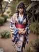 A woman in a blue and pink kimono posing for a picture.