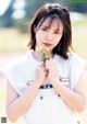 A young woman holding a flower in her hand.