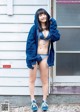 A woman in a blue hoodie and blue shorts posing for a magazine.